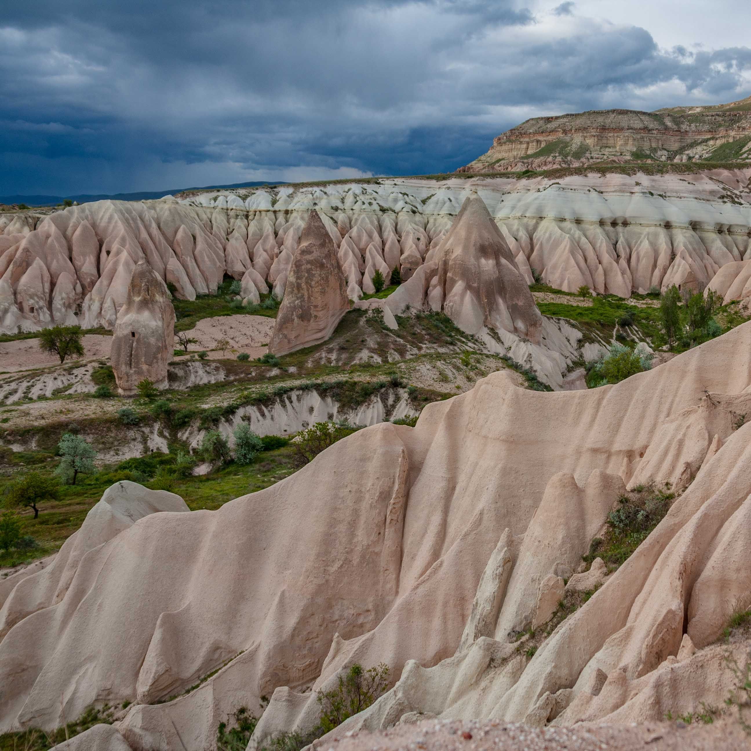 Sand dune shaped formations of Cappadocia on a rainy sky. 