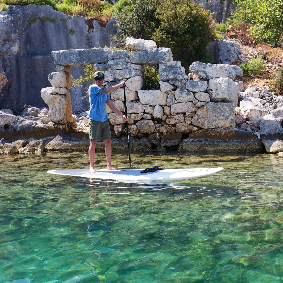 Paddleboarder passing by the ruins